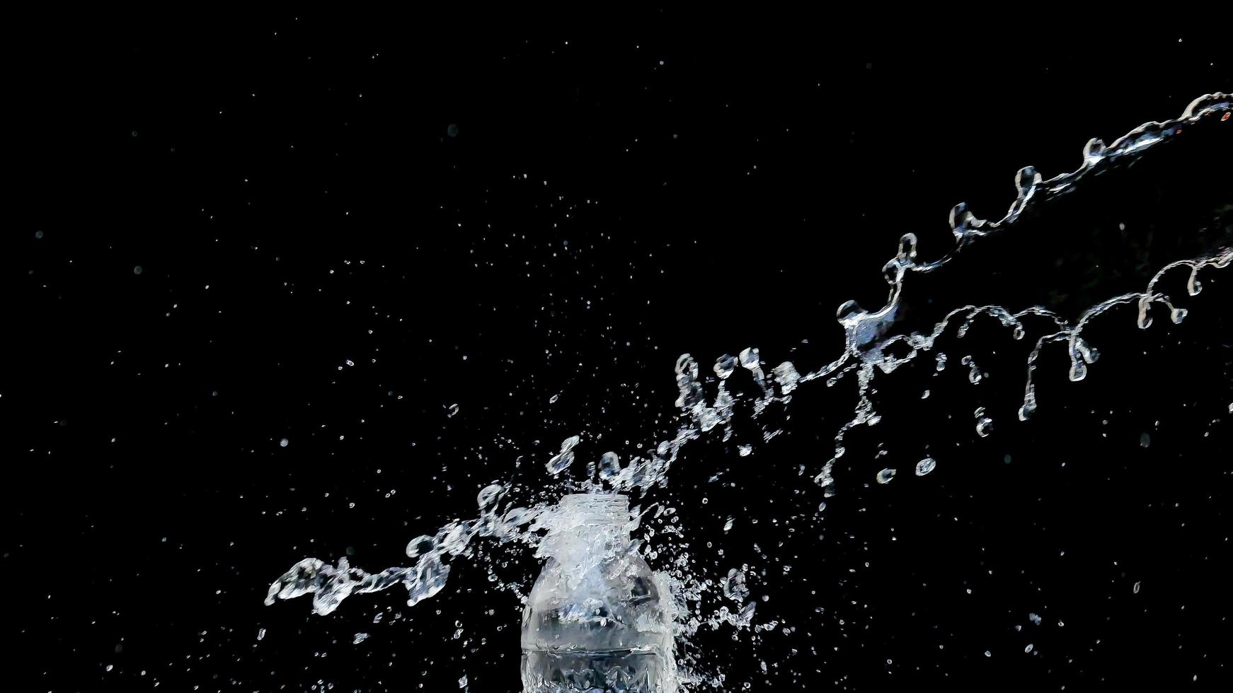 Abstract water jet crashes on a black background photo