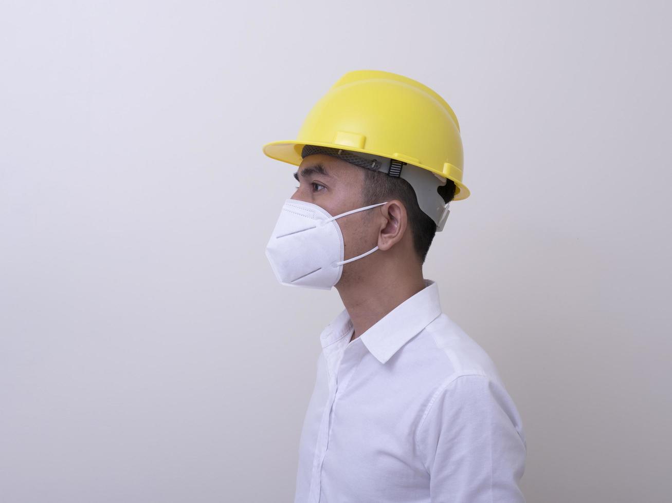 Asian industrial workers wear yellow hard hats, wear protective masks for their health photo