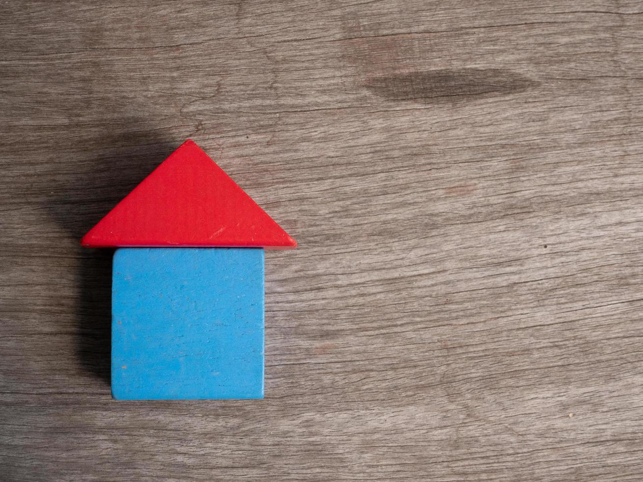 Wooden house toy with wood background photo