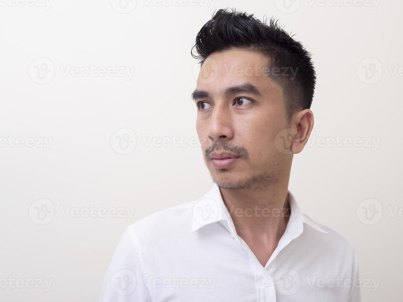 joven asiático aislado de fondo blanco mirando hacia los lados foto