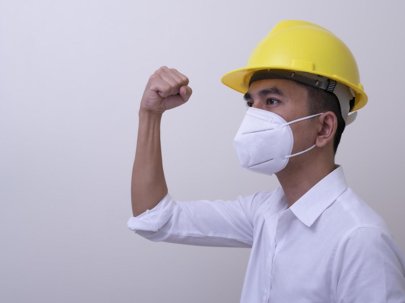 Asian industrial workers wear yellow hard hats, wear protective masks for their health photo