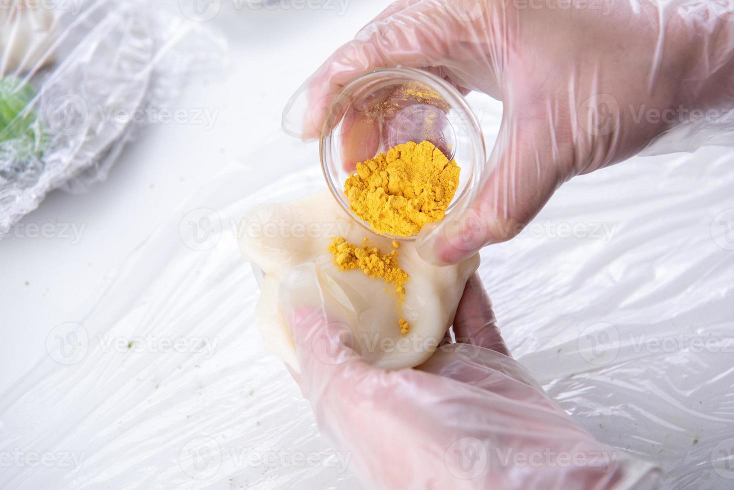 Young woman is making colorful snow skin moon cake, recipe of sweet snowy mooncake, traditional savory dessert for Mid-Autumn Festival, close up, lifestyle. photo