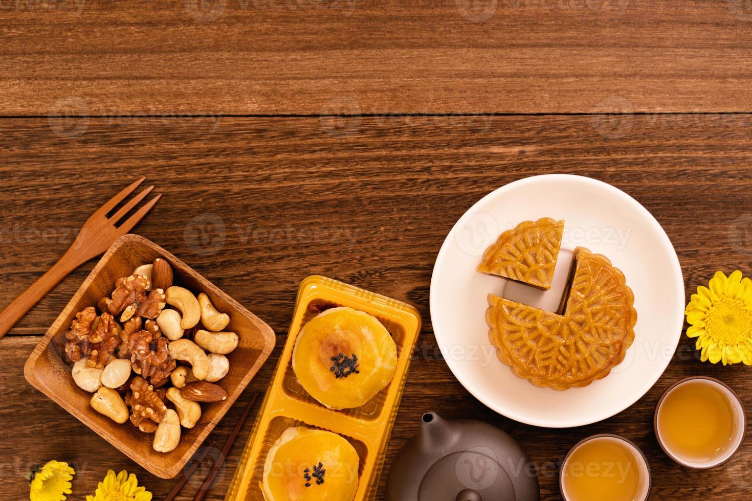 Moon cake for Mid-Autumn Festival, delicious beautiful fresh mooncake on a plate over dark wooden background table, top view, flat lay layout design concept. photo