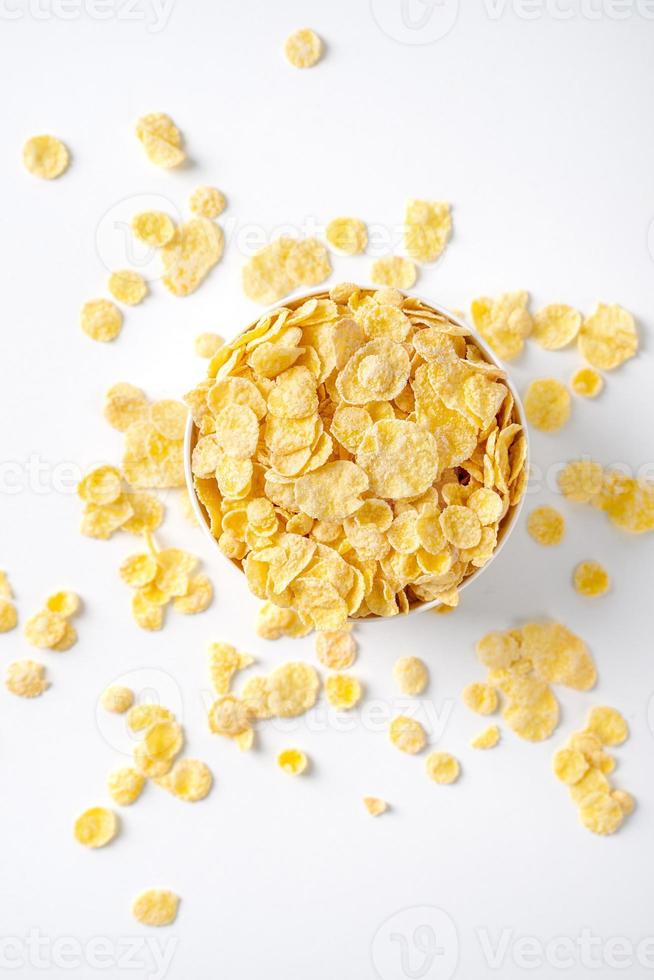 Corn flakes bowl sweeties with milk and orange on white background, top view, flat lay overhead layout, fresh and healthy breakfast design concept. photo