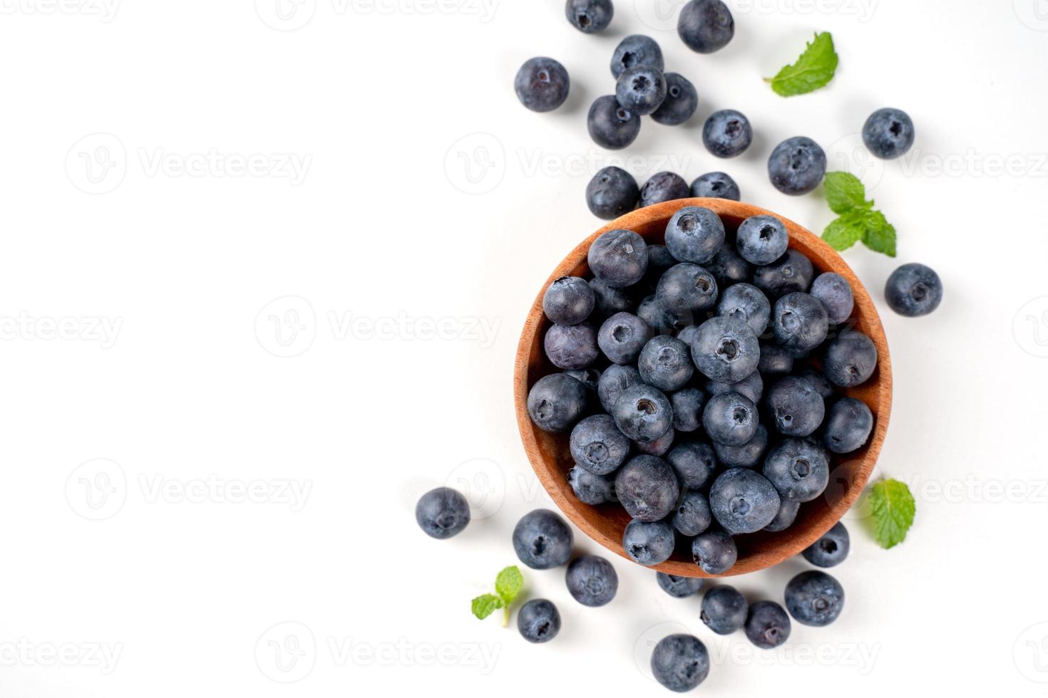 Blueberry fruit top view isolated on a white background, flat lay overhead layout with mint leaf, healthy design concept. photo