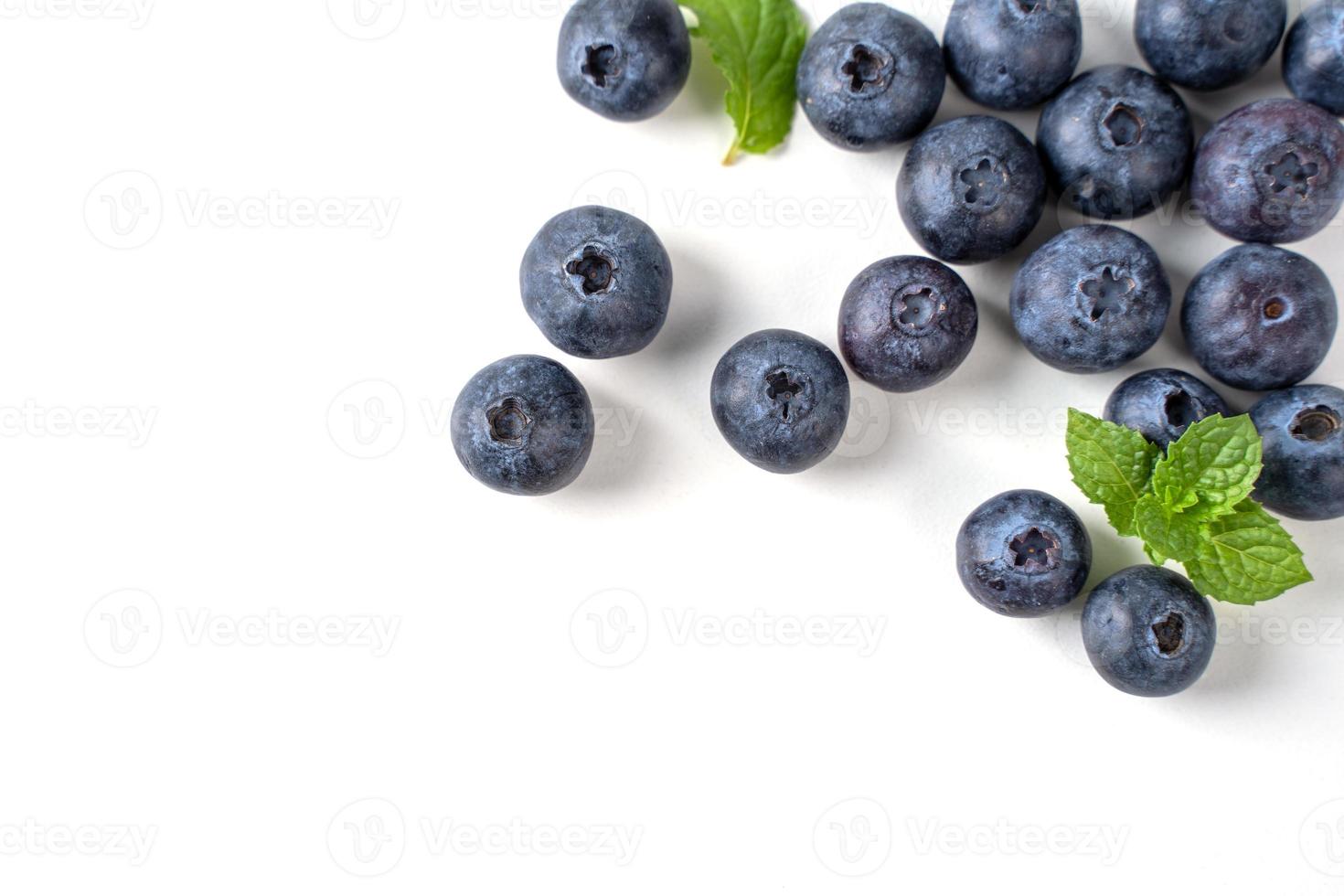 Blueberry fruit top view isolated on a white background, flat lay overhead layout with mint leaf, healthy design concept. photo