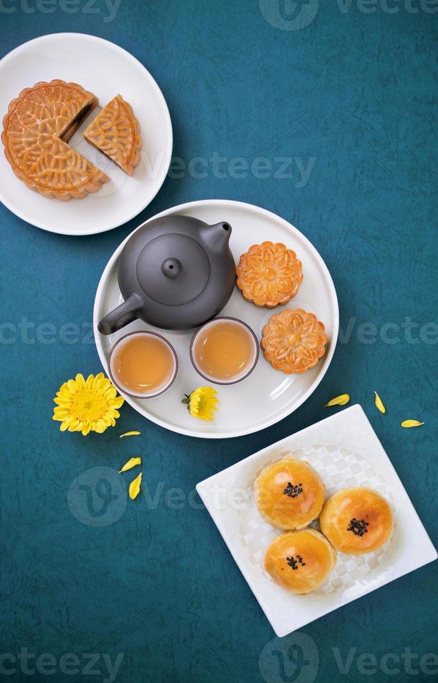 Moon cake for Mid-Autumn Festival, delicious beautiful fresh mooncake on a plate over blue background table, top view, flat lay layout design concept. photo