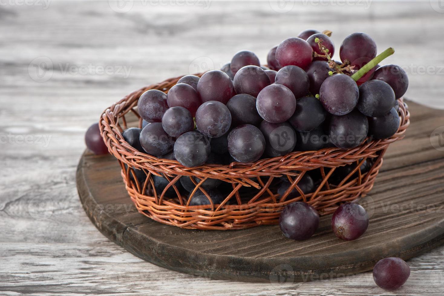 primer plano de racimo de uvas sobre fondo de mesa de madera. foto
