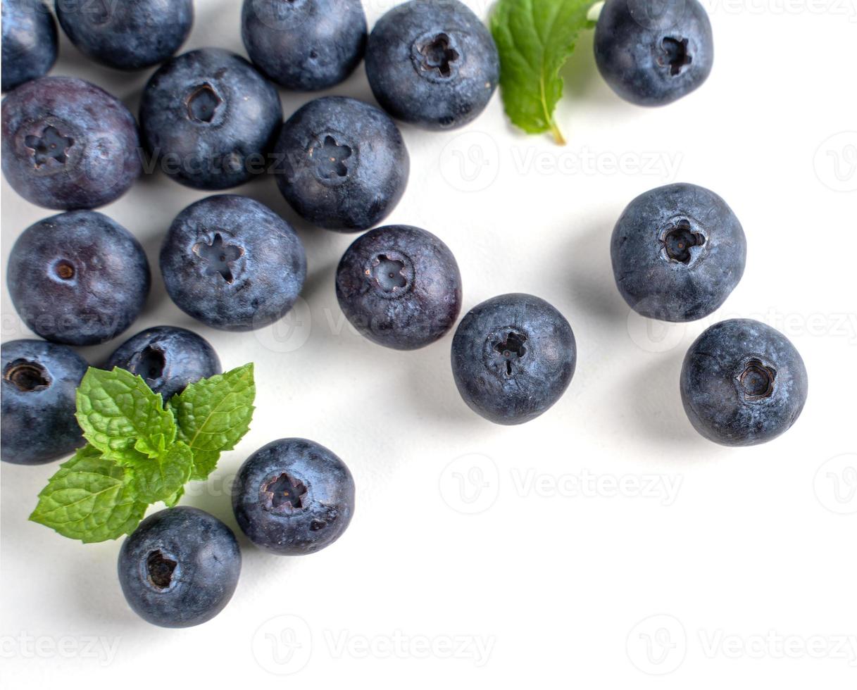 Blueberry fruit top view isolated on a white background, flat lay overhead layout with mint leaf, healthy design concept. photo