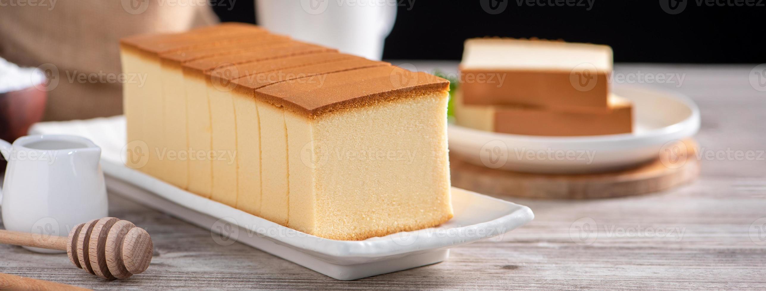 Castella kasutera - Delicious Japanese sliced sponge cake food on white plate over rustic wooden table, close up, healthy eating, copy space design. photo