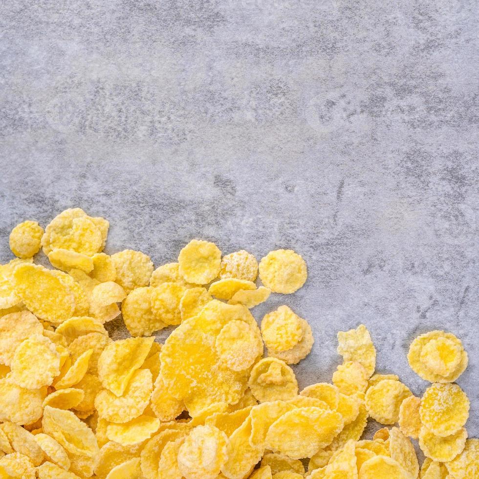 Corn flakes bowl sweets on gray cement background, top view flat lay layout design, fresh and healthy breakfast concept. photo