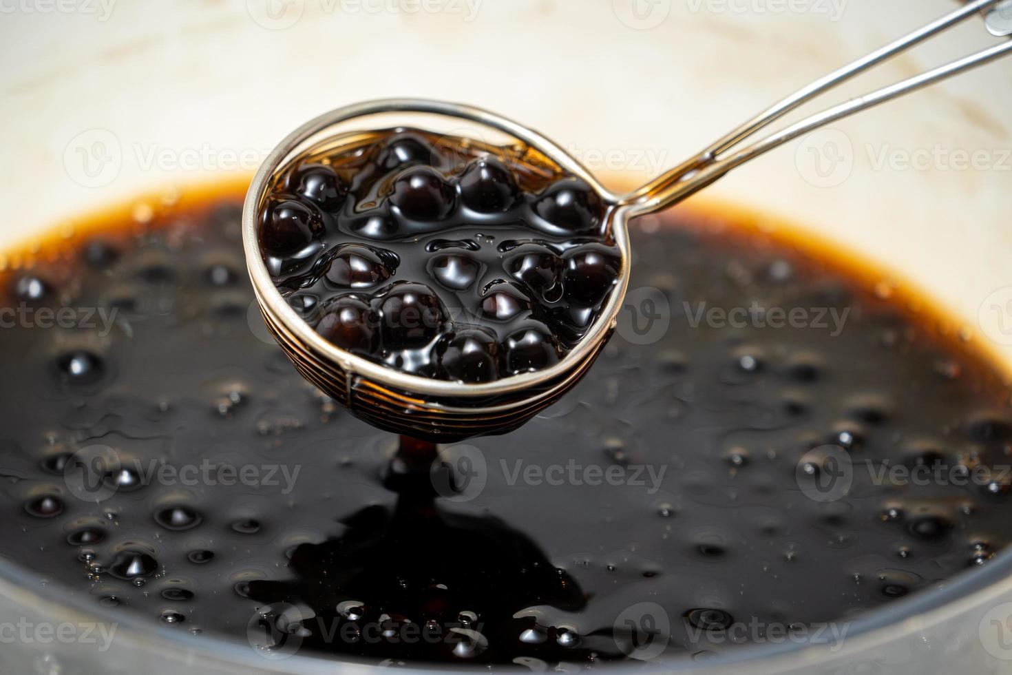 Cooking, boiling brown sugar flavor tapioca pearl balls, ingredient of bubble tea, preparing food and drink, close up, recipe cookbook steps design concept. photo