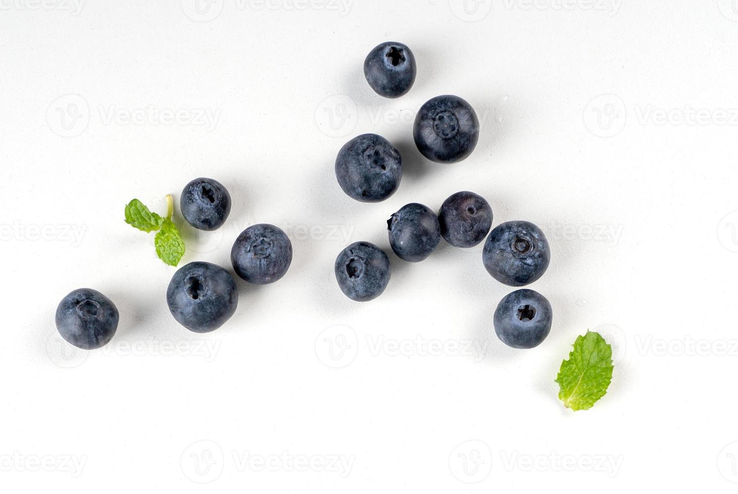 Blueberry fruit top view isolated on a white background, flat lay overhead layout with mint leaf, healthy design concept. photo