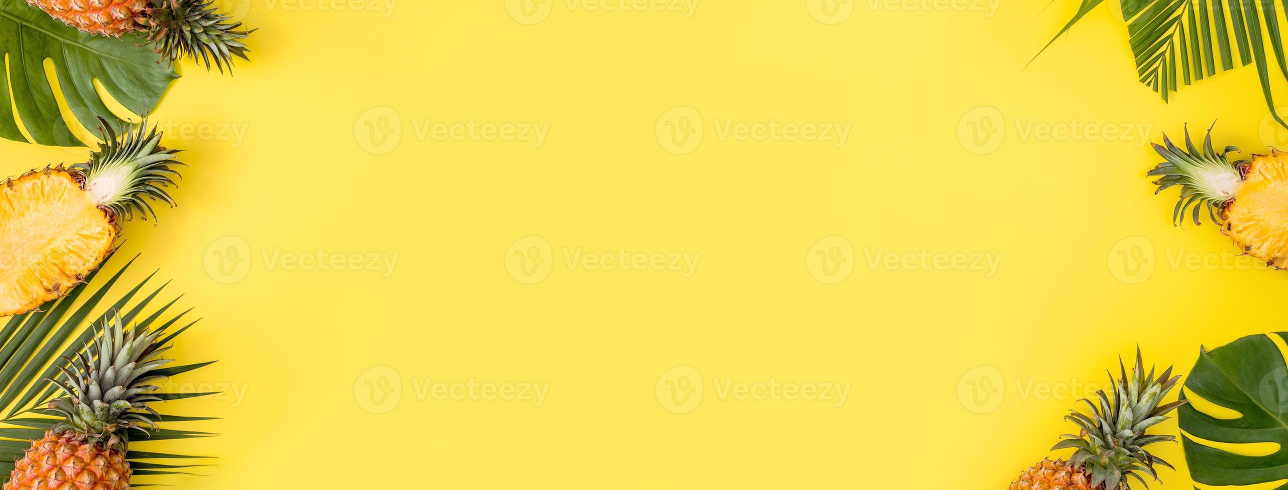 Beautiful pineapple on tropical palm monstera leaves isolated on bright pastel yellow background, top view, flat lay, overhead above summer fruit. photo