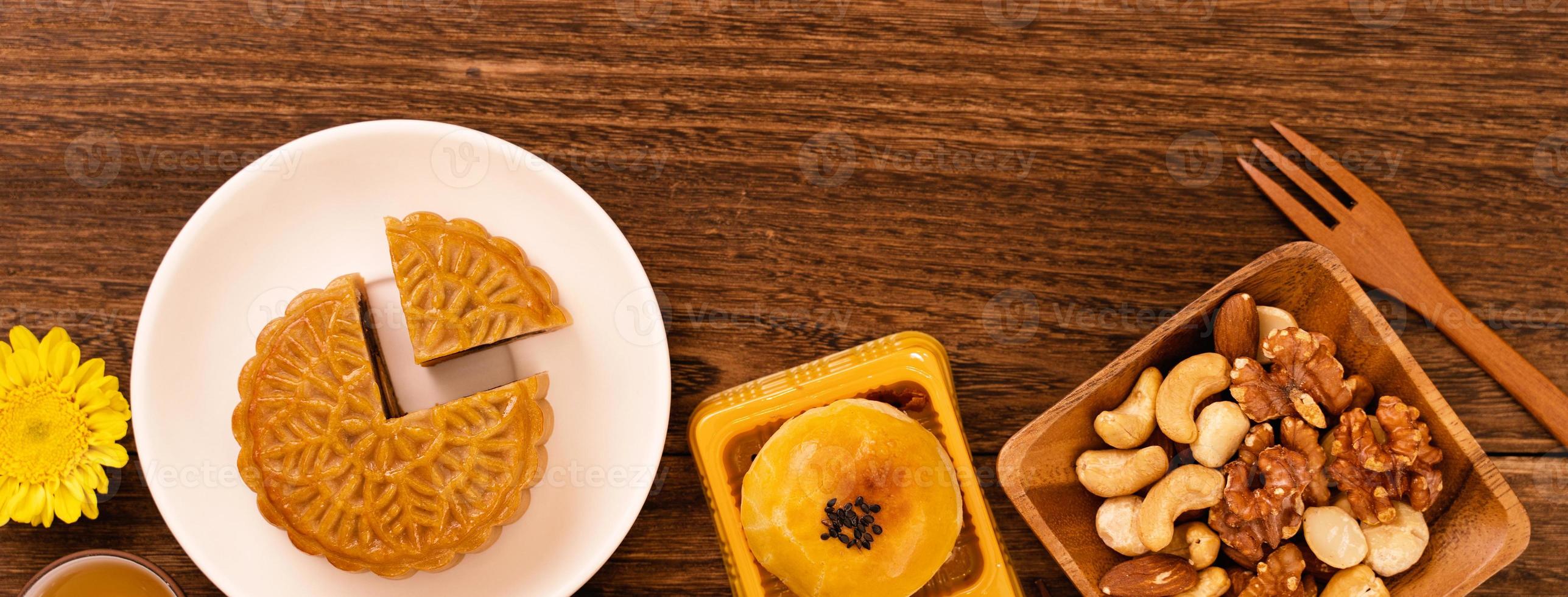 pastel de luna para el festival de mediados de otoño, delicioso y hermoso pastel de luna fresco en un plato sobre una mesa de fondo de madera oscura, vista superior, concepto de diseño plano. foto