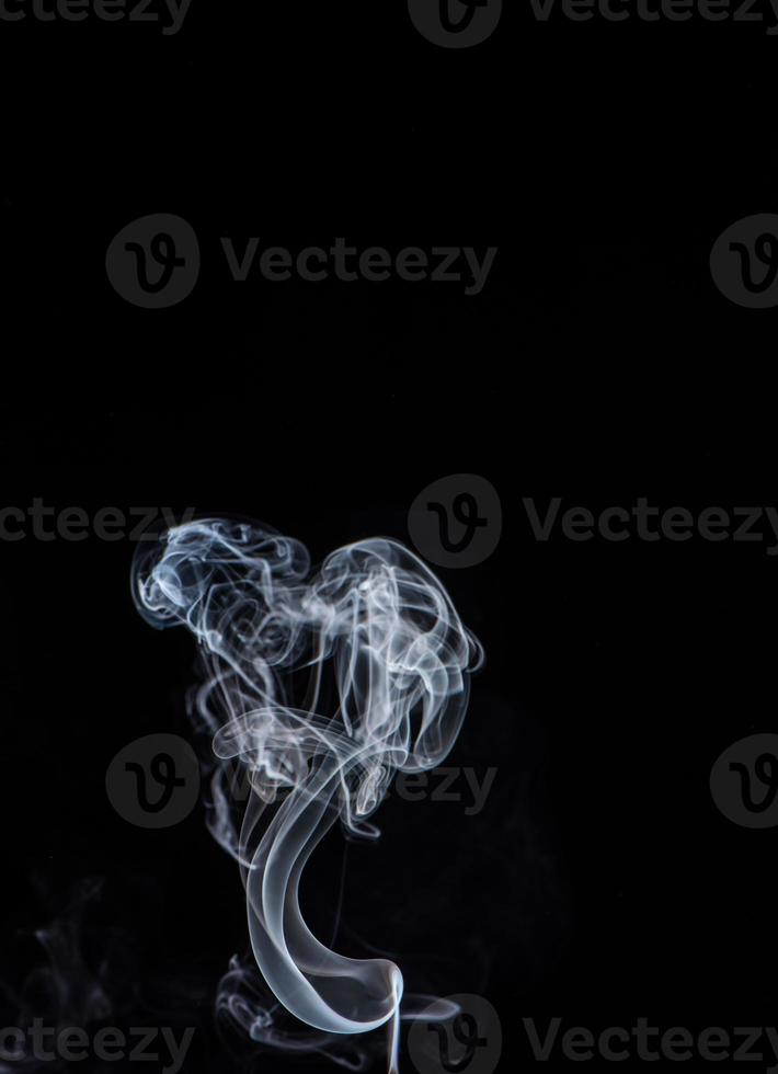 Conceptual image of white color smoke isolated on dark black background, Halloween design element concept. photo