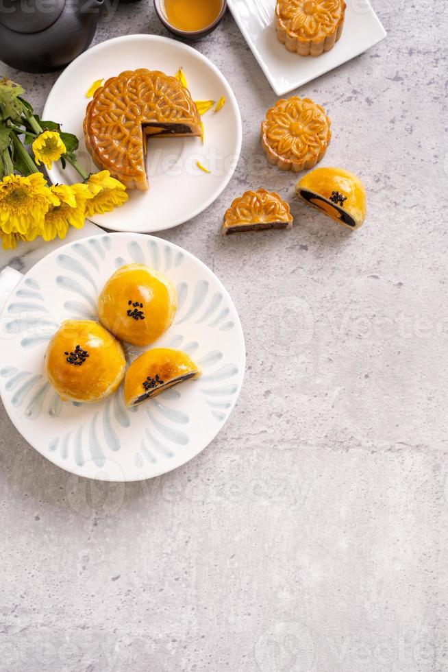 Tasty baked egg yolk pastry moon cake for Mid-Autumn Festival on bright cement table background. Chinese traditional food concept, close up, copy space. photo