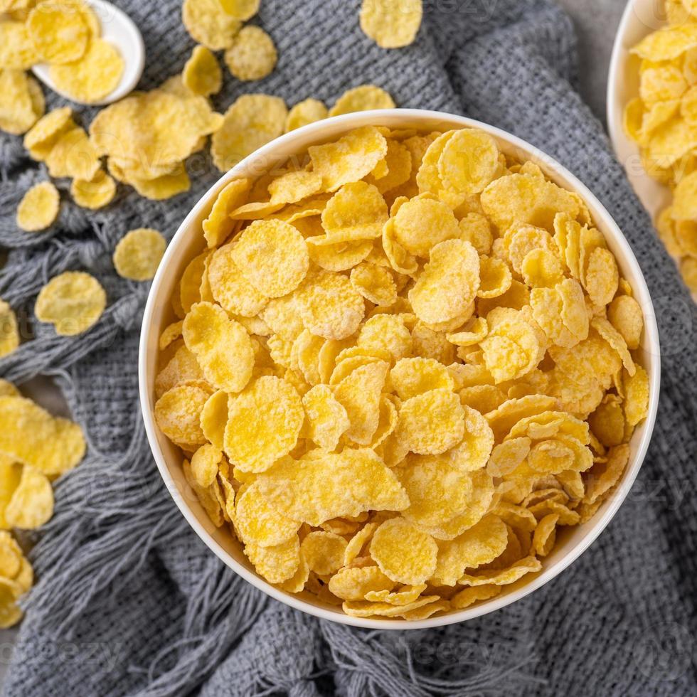 Corn flakes bowl sweets on gray cement background, top view flat lay layout design, fresh and healthy breakfast concept. photo