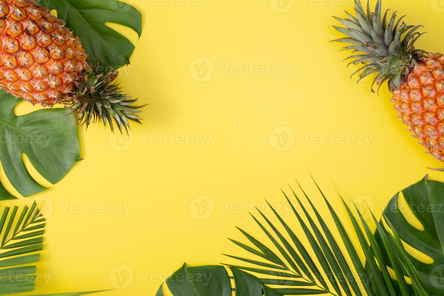 Beautiful pineapple on tropical palm monstera leaves isolated on bright pastel yellow background, top view, flat lay, overhead above summer fruit. photo