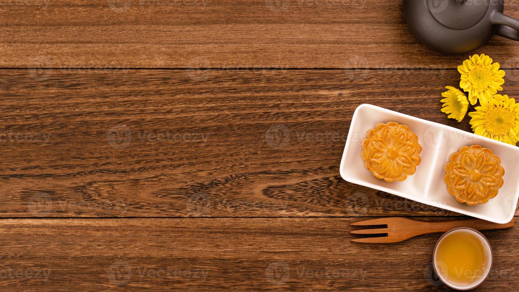 Moon cake for Mid-Autumn Festival, delicious beautiful fresh mooncake on a plate over dark wooden background table, top view, flat lay layout design concept. photo