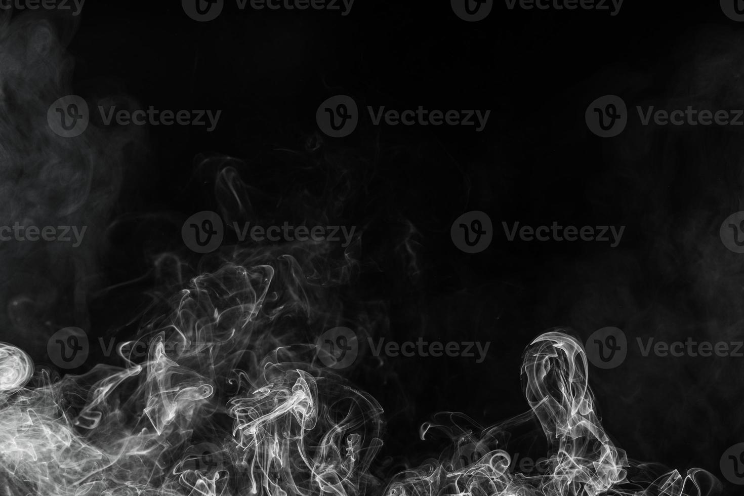 Conceptual image of white color smoke isolated on dark black background, Halloween design element concept. photo