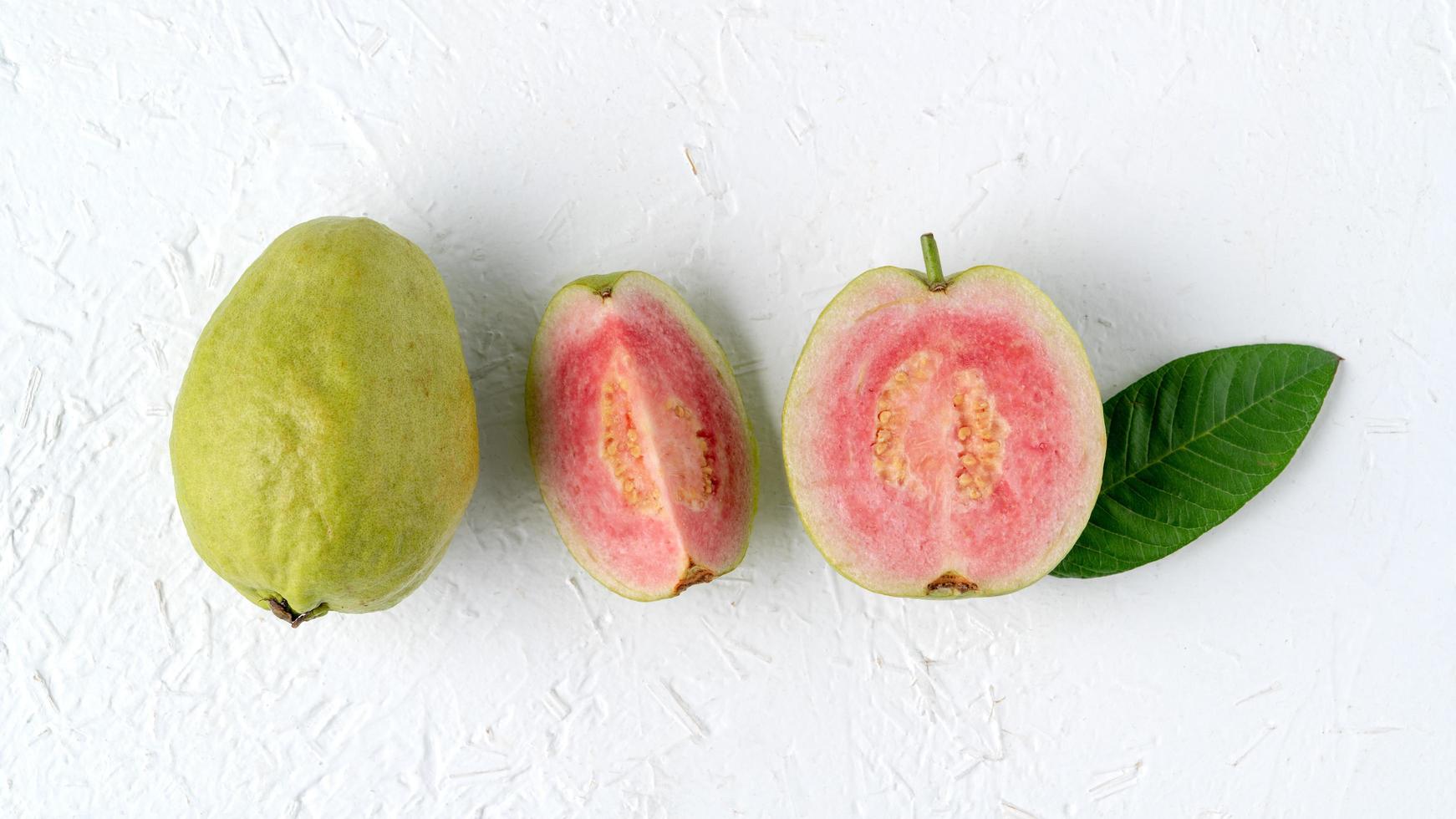 Top view of beautiful red guava with fresh green leaves. photo