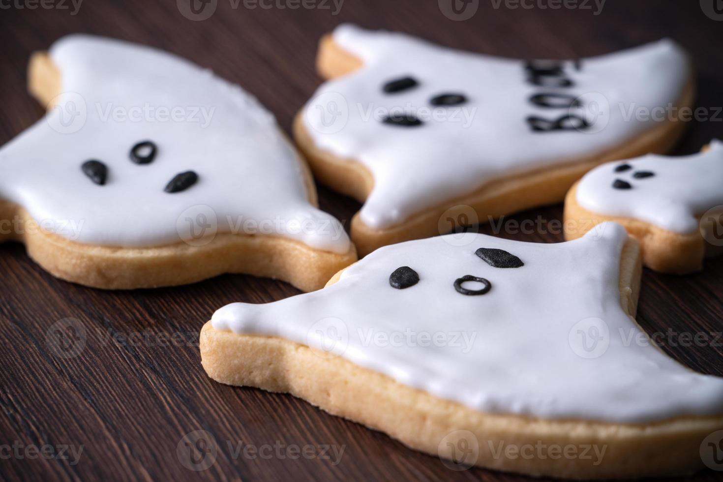 Close up of decorating cute Halloween ghost cookies with frosting. photo