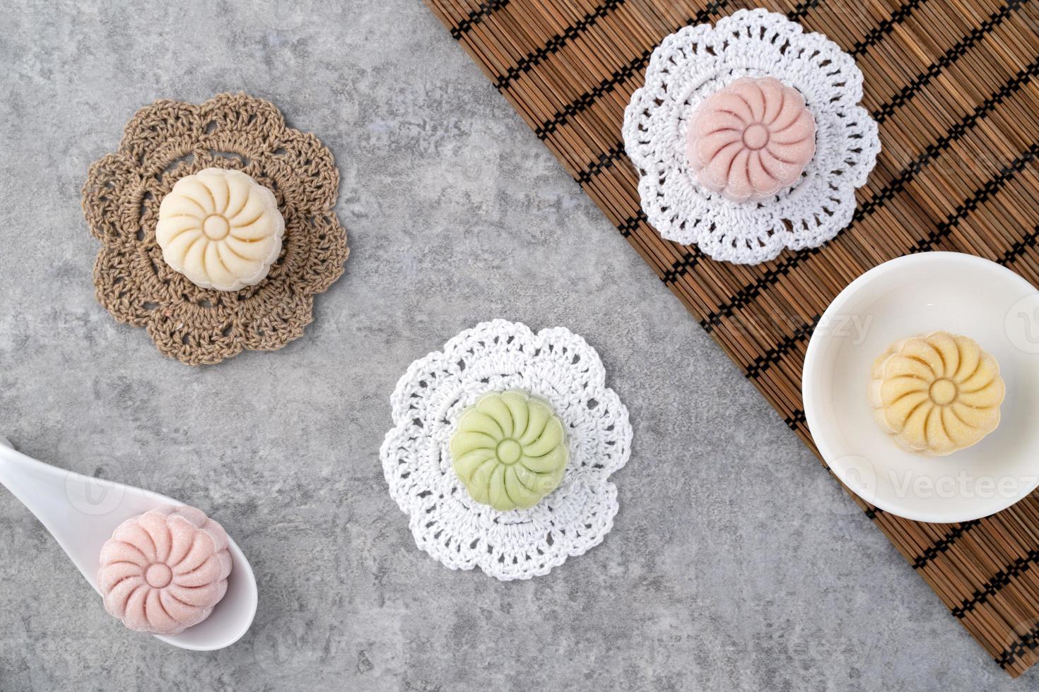 Colorful snow skin moon cake, sweet snowy mooncake, traditional savory dessert for Mid-Autumn Festival on gray cement background, top view photo