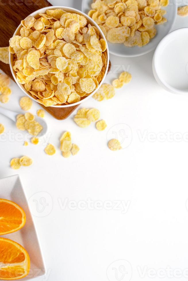 Top view of corn flakes bowl with milk on white background. photo