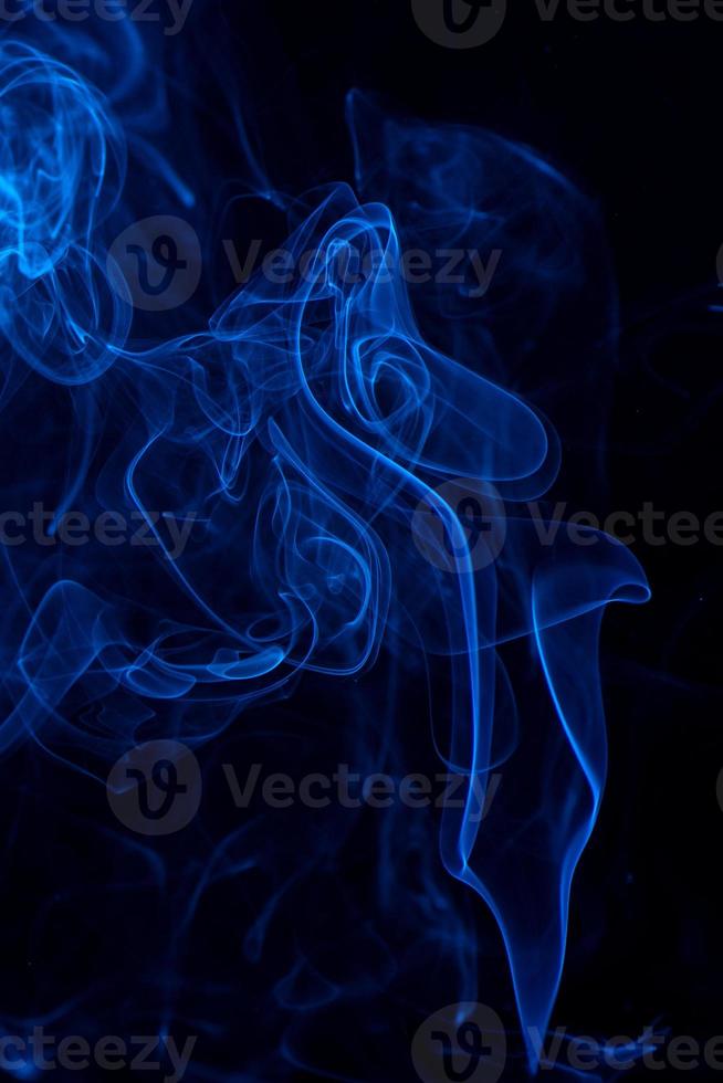 imagen conceptual de humo de color azul aislado sobre fondo negro oscuro, concepto de elemento de diseño de Halloween. foto