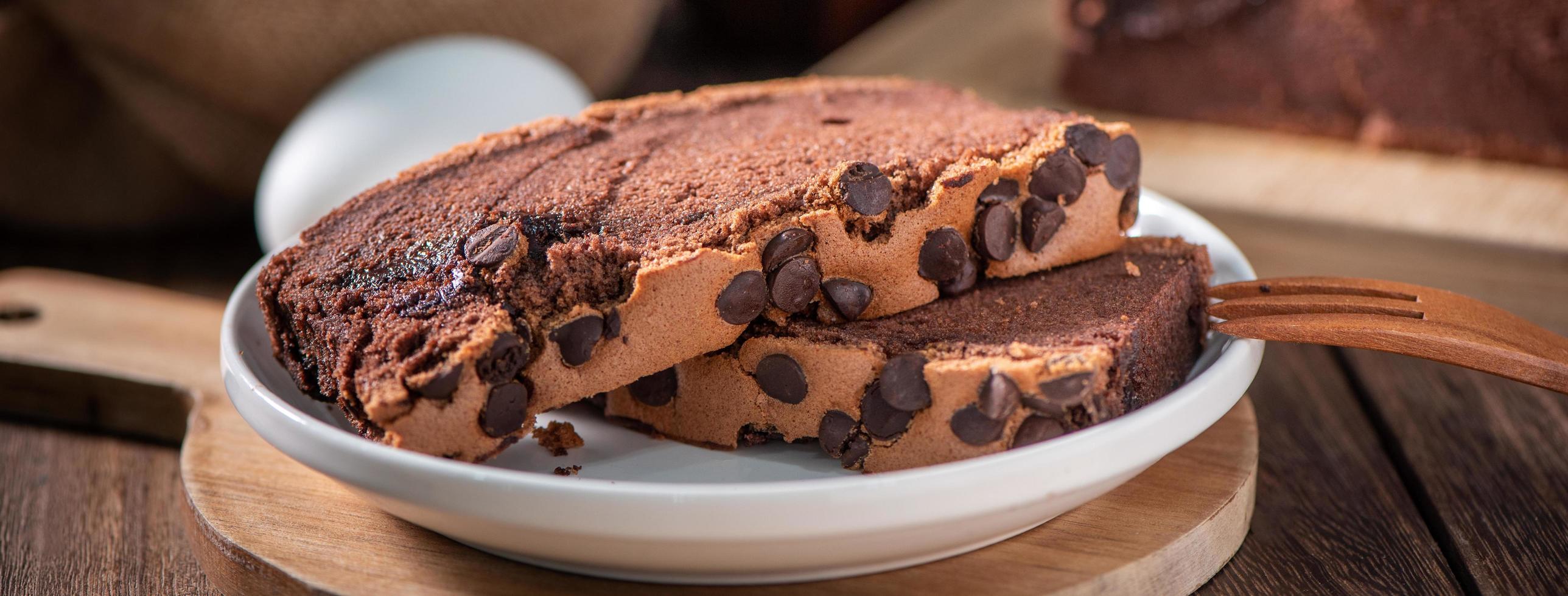 bizcocho tradicional taiwanés con sabor a chocolate taiwanés castella kasutera sobre una mesa de fondo de bandeja de madera con ingredientes, de cerca. foto