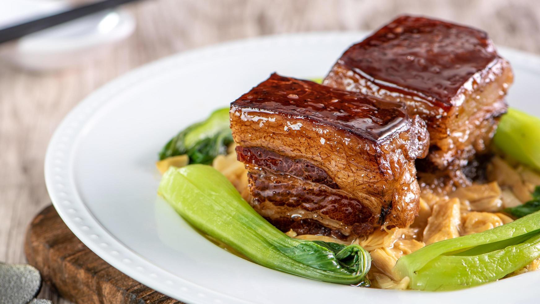 Dong Po Rou Dongpo pork meat in a beautiful blue plate with green broccoli vegetable, traditional festive food for Chinese new year cuisine meal, close up. photo