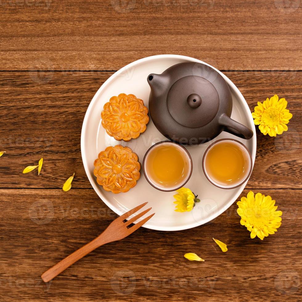 Moon cake for Mid-Autumn Festival, delicious beautiful fresh mooncake on a plate over dark wooden background table, top view, flat lay layout design concept. photo
