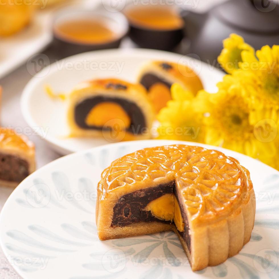 Tasty baked egg yolk pastry moon cake for Mid-Autumn Festival on bright cement table background. Chinese traditional food concept, close up, copy space. photo