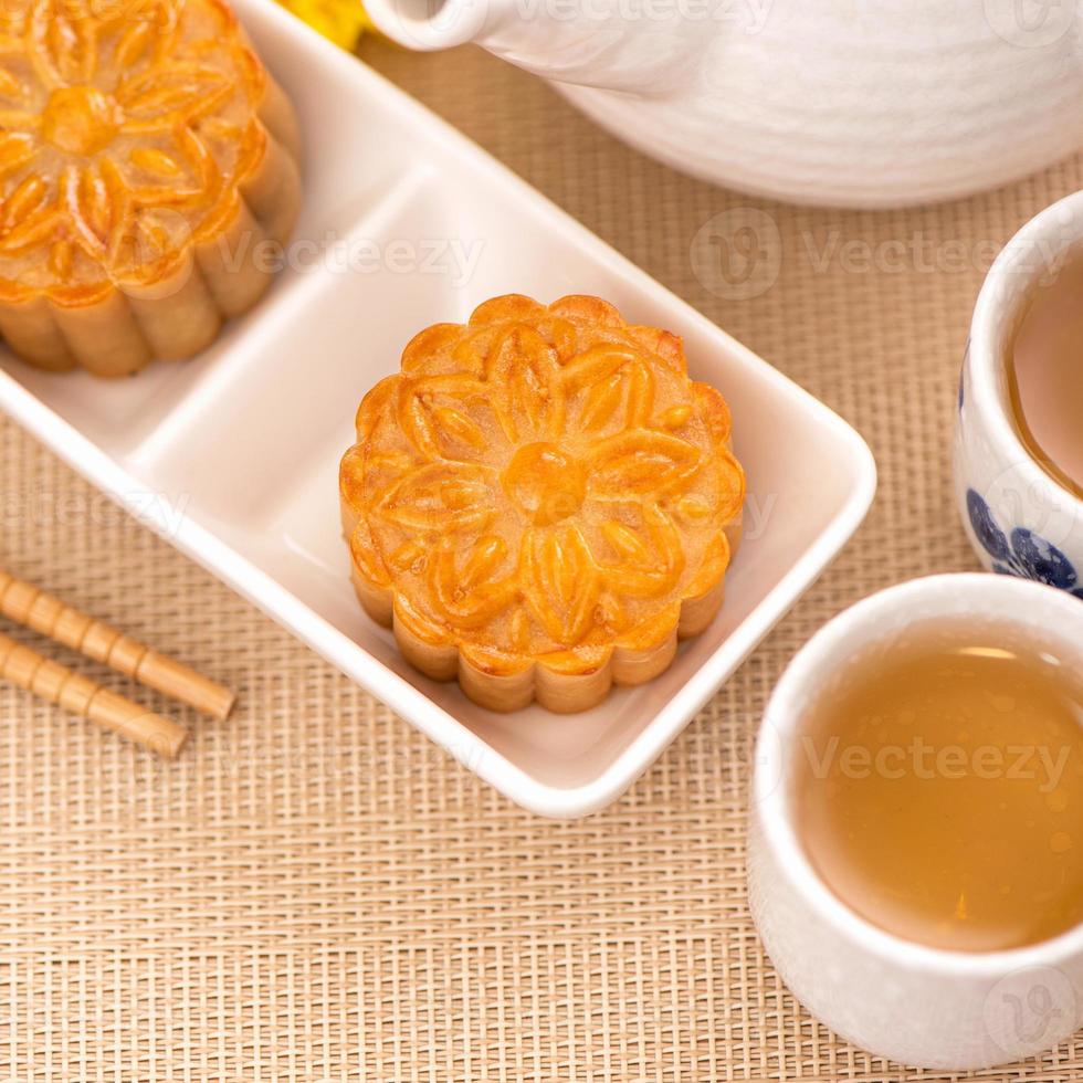 Tasty baked egg yolk pastry moon cake for Mid-Autumn Festival on bright wooden table background. Chinese festive food concept, close up, copy space. photo