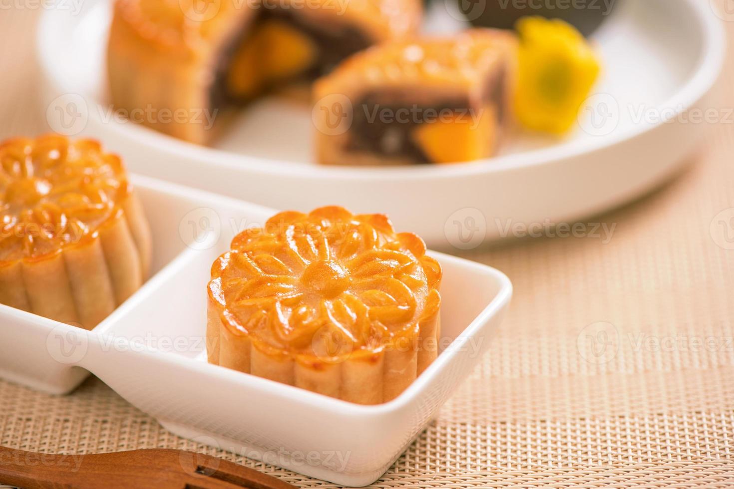 Tasty baked egg yolk pastry moon cake for Mid-Autumn Festival on bright wooden table background. Chinese festive food concept, close up, copy space. photo