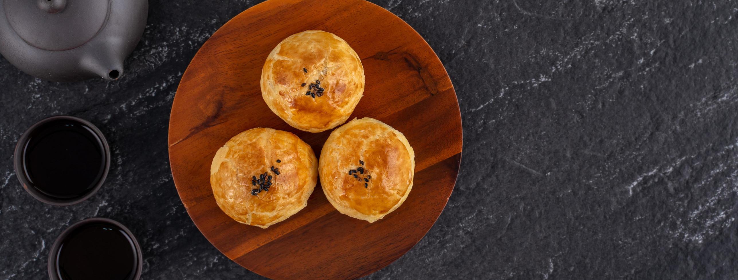 Moon cake yolk pastry, mooncake for Mid-Autumn Festival holiday, top view design concept on dark wooden table with copy space, flat lay, overhead shot photo