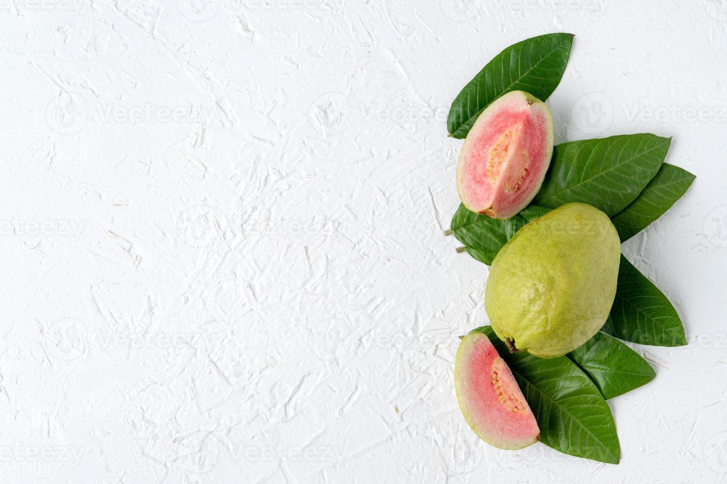 Top view of beautiful red guava with fresh green leaves. photo