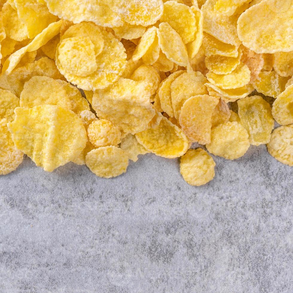 Corn flakes bowl sweets on gray cement background, top view flat lay layout design, fresh and healthy breakfast concept. photo
