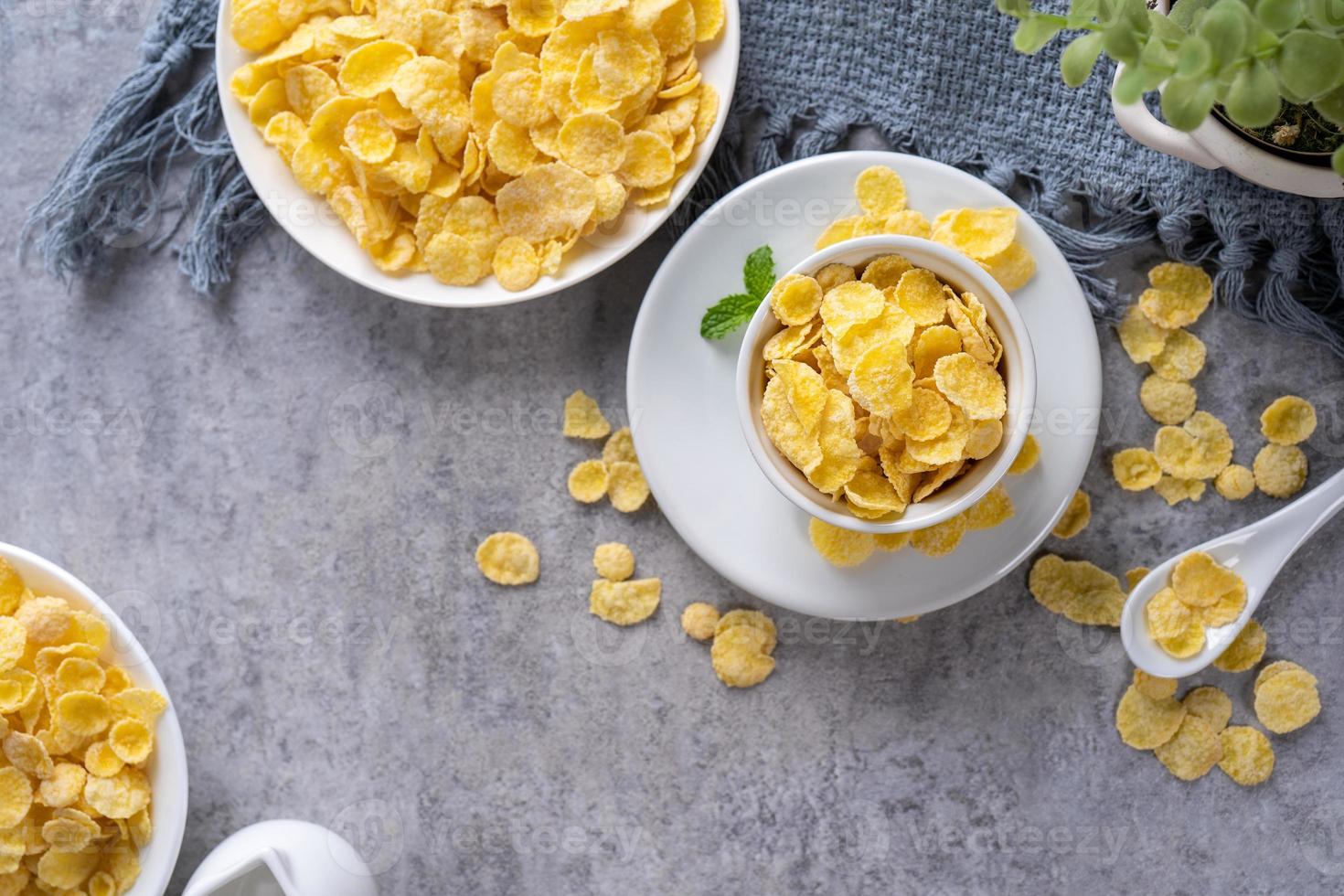 Corn flakes bowl sweets on gray cement background, top view flat lay layout design, fresh and healthy breakfast concept. photo