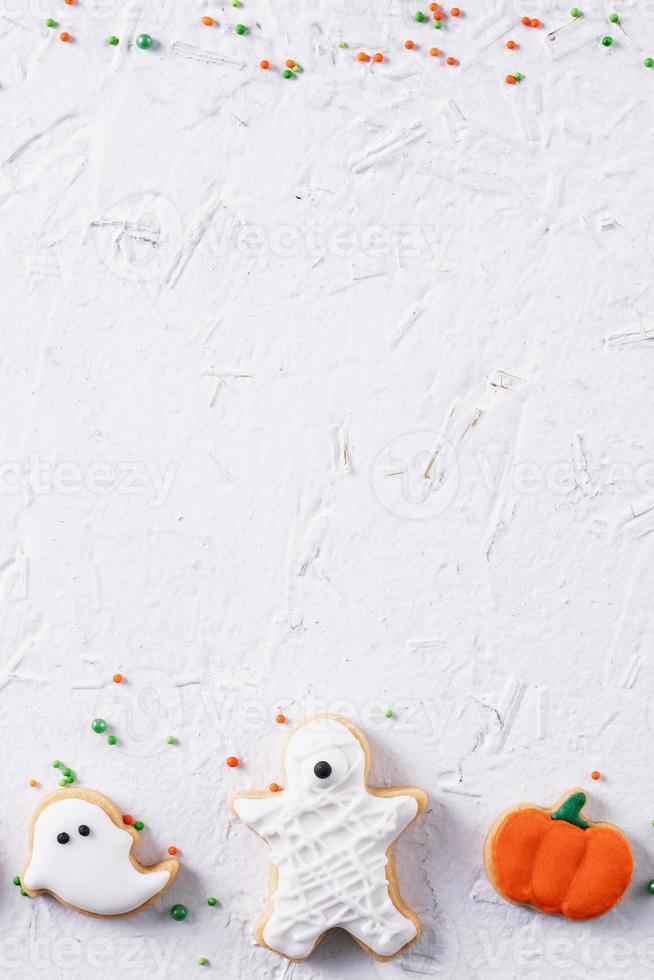 Top view of Halloween festive decorated icing sugar cookies on white background. photo