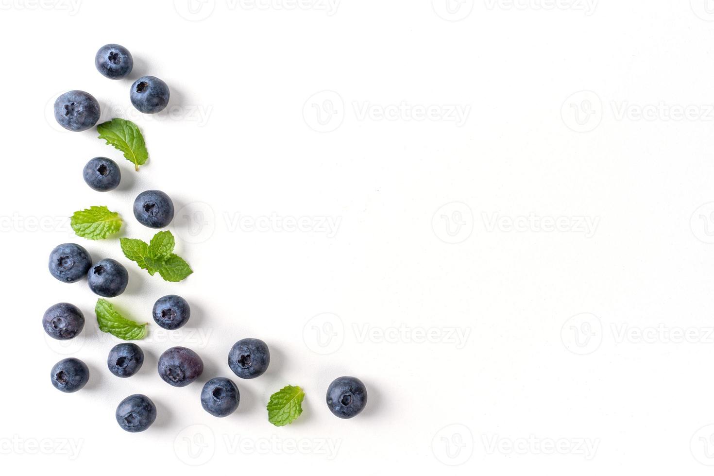 vista superior de la fruta de arándano aislada en un fondo blanco, diseño plano superior con hoja de menta, concepto de diseño saludable. foto