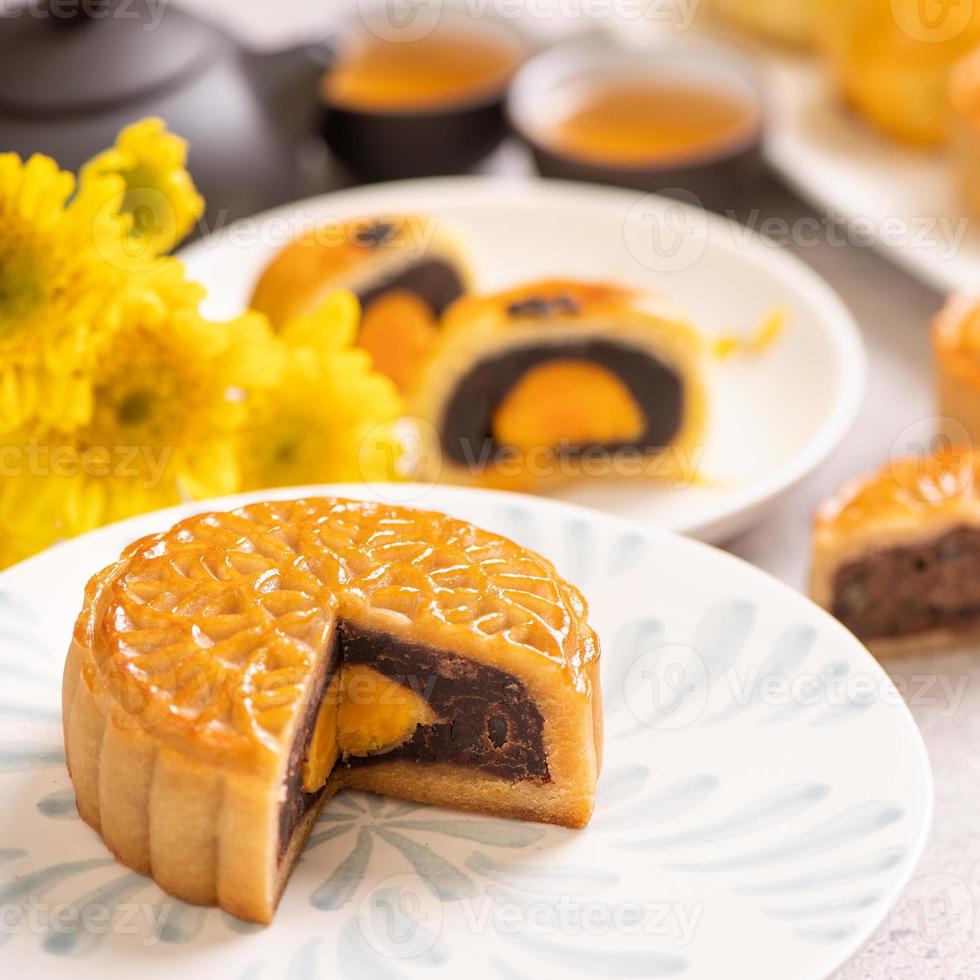 Tasty baked egg yolk pastry moon cake for Mid-Autumn Festival on bright cement table background. Chinese traditional food concept, close up, copy space. photo
