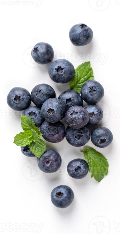 Blueberry fruit top view isolated on a white background, flat lay overhead layout with mint leaf, healthy design concept. photo