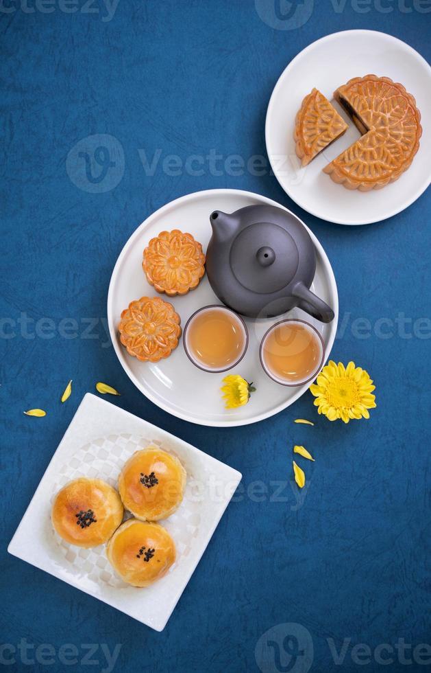 Moon cake for Mid-Autumn Festival, delicious beautiful fresh mooncake on a plate over blue background table, top view, flat lay layout design concept. photo