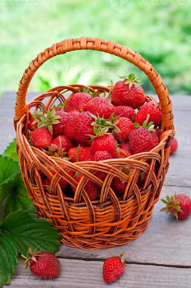 fresas frescas en una cesta sobre una mesa en el jardín foto