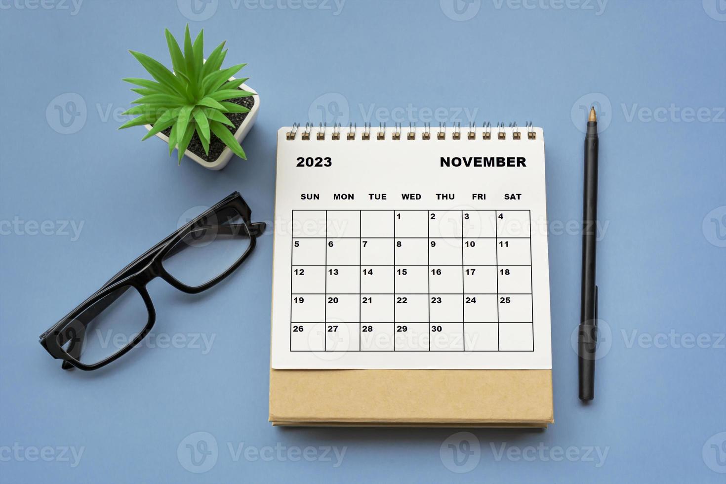 November 2023 desk calendar on blue background. Directly above. Flat lay. photo