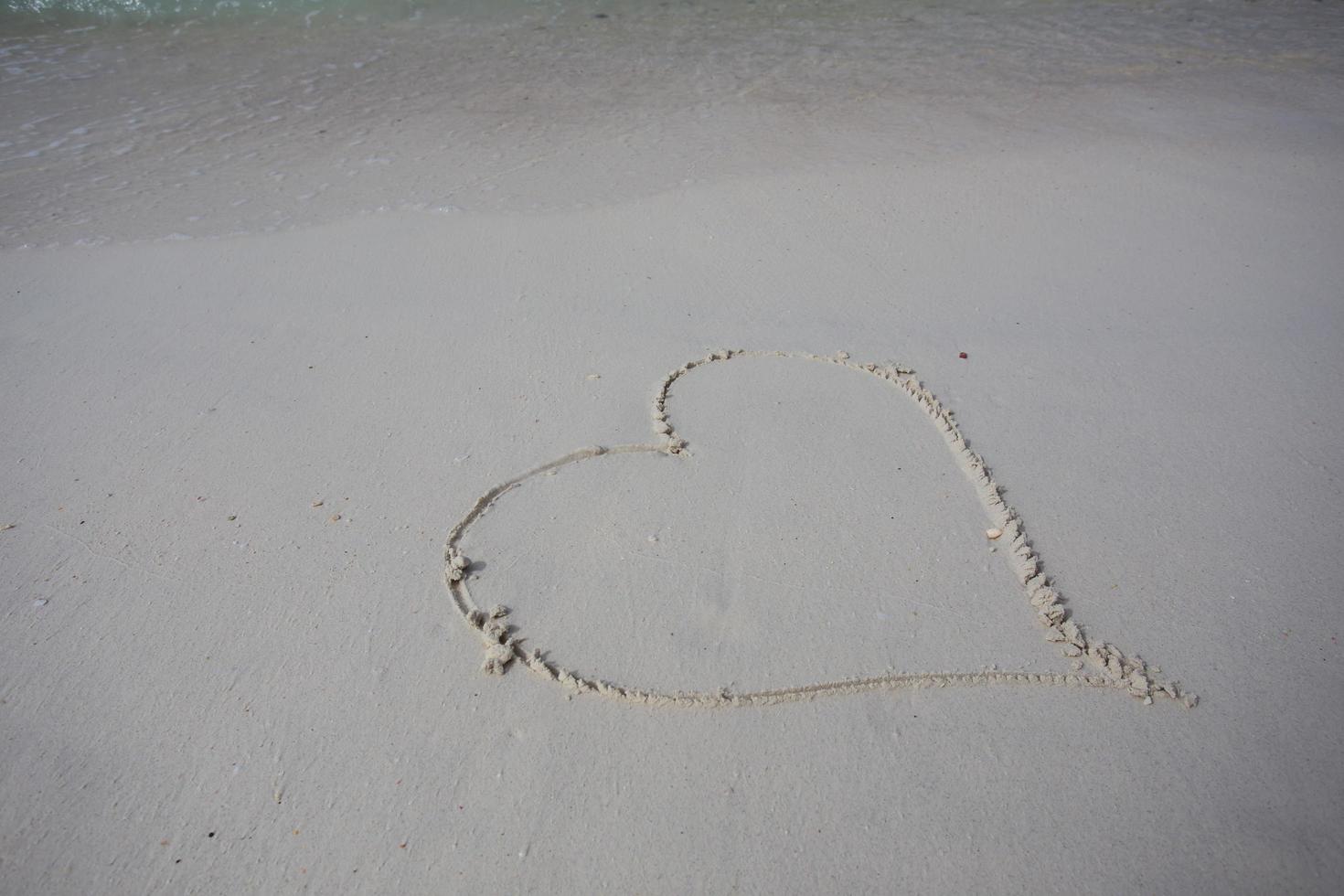 hearts drawn on the sand of a beach photo