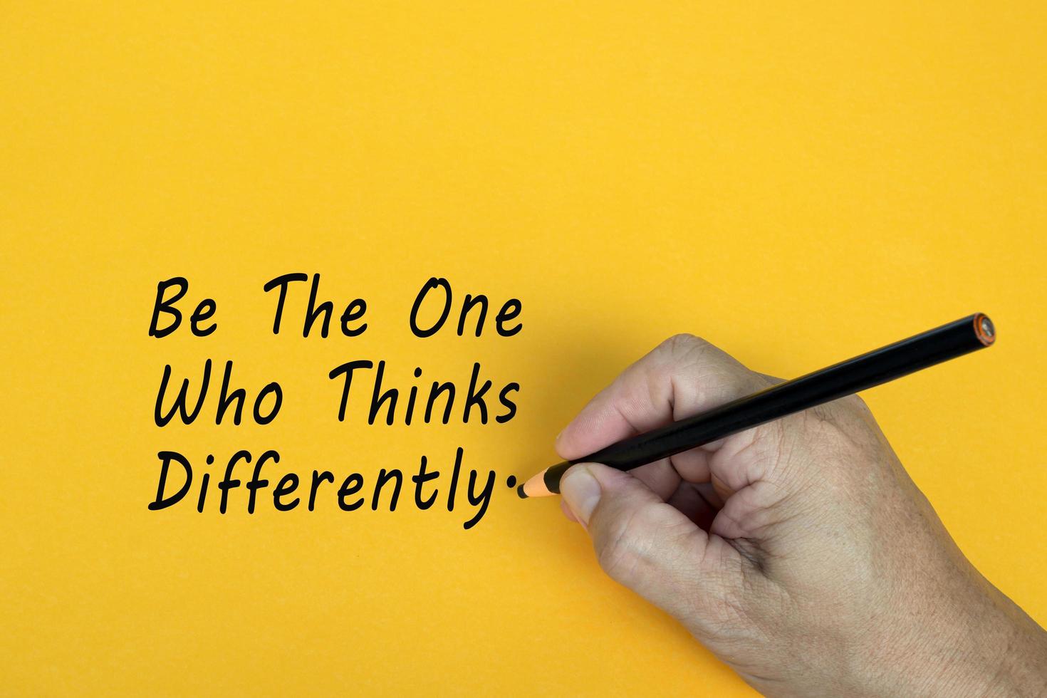 BE THE ONE WHO THINKS DIFFERENTLY text written on a yellow background. Business concept. photo