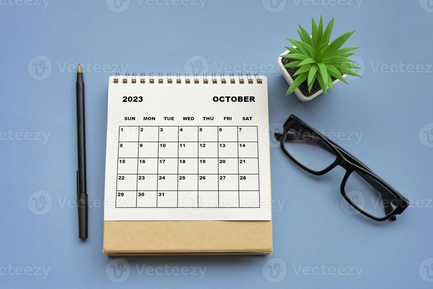 October 2023 desk calendar on blue background. Directly above. Flat lay. photo